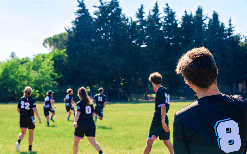 Players strategize, analyze, and improve their Ultimate Frisbee game plan, focusing on teamwork and tactics to enhance their performance