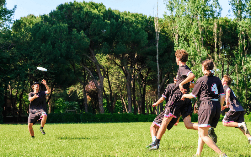 A group of players on a field, throwing and catching a frisbee, with a sense of teamwork and camaraderie in the air